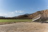 A photo of a soccer field with bleachers